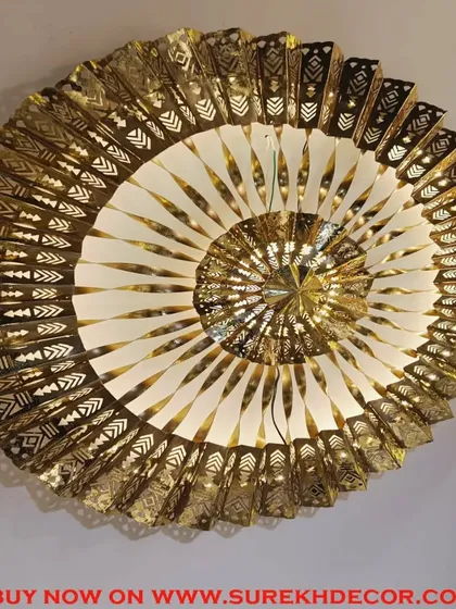 This exclusive imported metal wall art is a true statement piece. The intricate, spiraling design in antique gold features detailed cutouts and is fitted with LED lights, creating a mesmerizing and luxurious focal point.