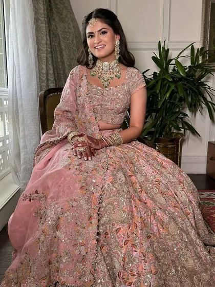 The full look for the sister of the bride. The soft, romantic makeup pairs beautifully with her intricate pink lehenga, creating a look that is both youthful and elegant.