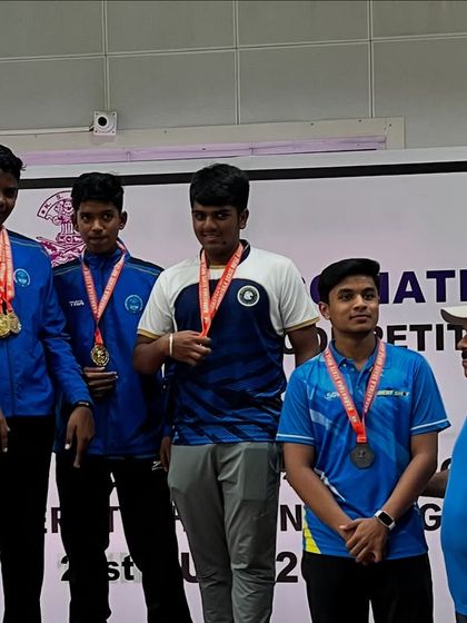 Our young men's Air Pistol team on the podium, celebrating their team medals.