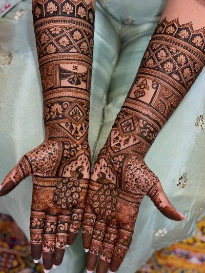 A full view of a symmetrical bridal mehendi, featuring peacocks and auspicious symbols. The design is dense and intricate, perfect for a grand celebration.