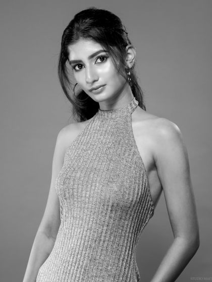 A black and white portrait of a model in a halter dress, with a classic and timeless feel.