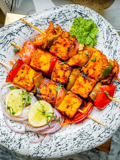 Another look at our delicious paneer tikka, beautifully plated on a stone-textured dish with fresh garnishes.