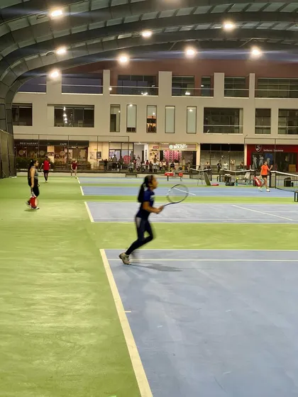 A player in motion during a night match at our facility. Our well-lit courts provide an excellent environment for evening training and competition.