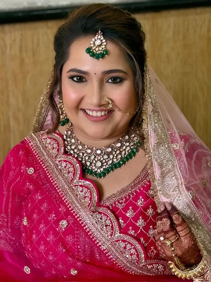 A happy bride is the most beautiful bride. This close-up captures the radiant smile and glowing makeup, complete with a traditional nose ring and emerald jewelry.