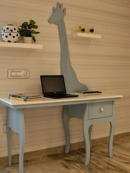 The study area from the same kids' room, featuring a whimsical giraffe silhouette integrated into the desk design, making homework time a little more fun.