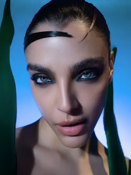 An extreme close-up from our aquatic-themed shoot. The focus here is entirely on the dramatic, wet-look makeup and the model's piercing eyes, creating an intimate and intense beauty shot.