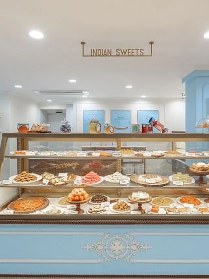 The main sweets counter at the flagship store was designed to be the centerpiece. With its classic wooden frame, elegant blue accents, and beautiful display of mithai, it serves as the heart of the shop, inviting customers to explore the delicious offerings.