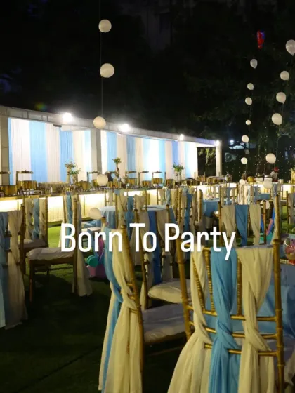 A nighttime view of the mermaid-themed party. The lighting adds a magical glow to the blue and white decor, creating an enchanting underwater ambiance for an evening celebration.