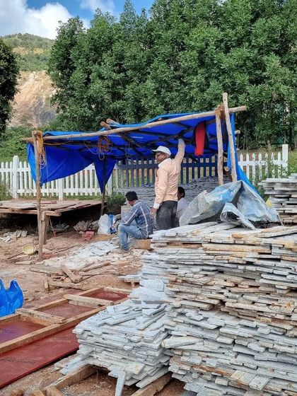 A temporary workshop on the Nandi Hills site, where local artisans prepare the granite off-cuts for the building's walls.