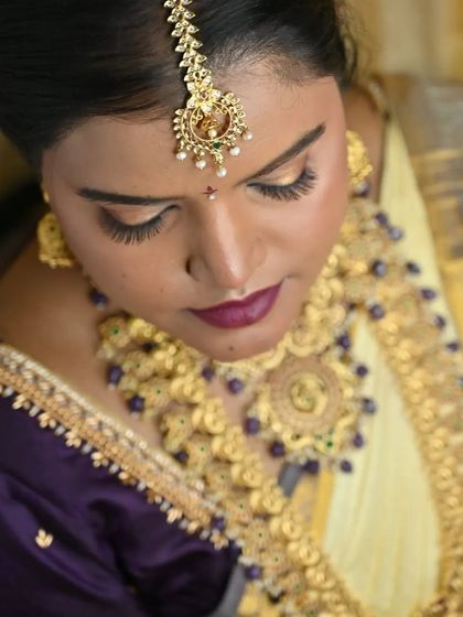 A detailed look at the eye makeup. The blend of gold and bronze tones on the eyelid creates a sophisticated and timeless look that enhances the bride's eyes.