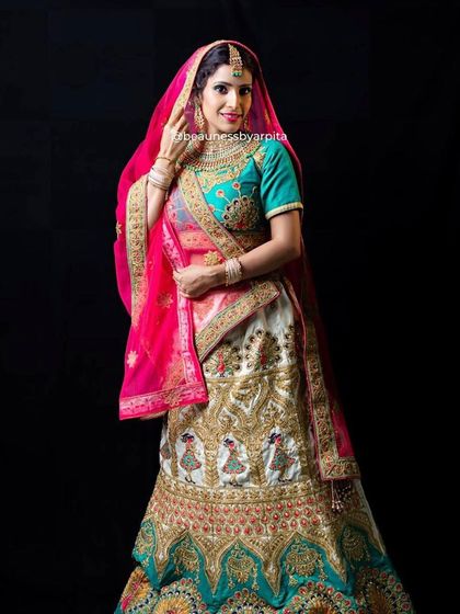 The full view of this unique lehenga with peacock motifs, combining shades of teal, pink, and cream for a truly festive look.