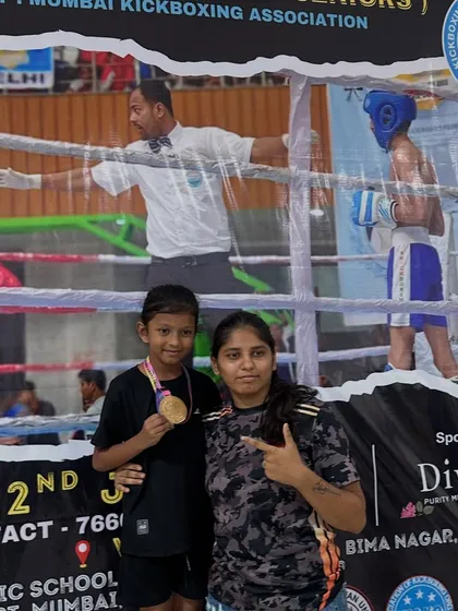 Coach Heena with one of our gold medal winners. Our coaching staff is dedicated to the success of every child, providing expert guidance and support.