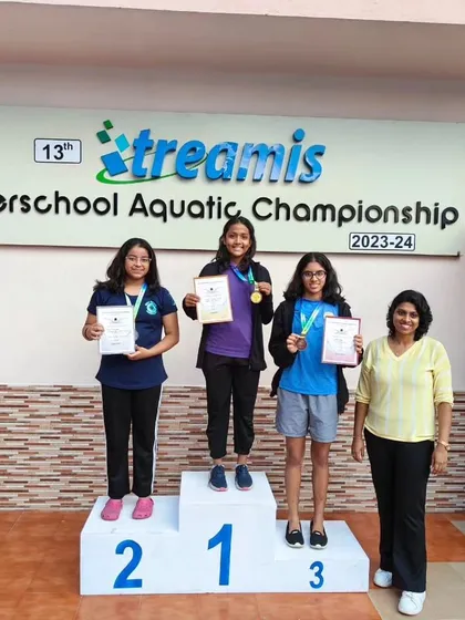 A proud coach and proud swimmers on the podium. These moments are a culmination of months of hard work and dedication from the entire team.