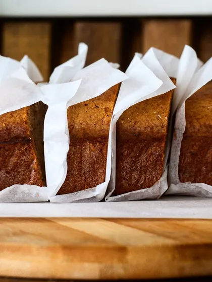 Slices of banana bread lined up on a wooden board. The simple, clean presentation is perfect for a cafe's menu or online ordering platform.