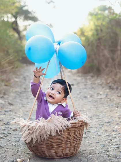 A joyful moment as he reaches for the balloons. Outdoor sessions are great for capturing energetic and playful shots.