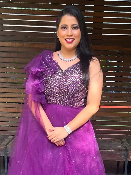 A close-up of the purple gown look. The makeup is sophisticated with a bold lip color that perfectly matches the glamorous feel of the outfit.