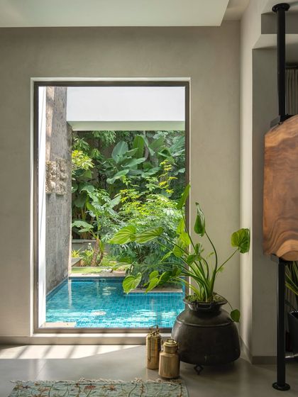 A view through a window from inside a home, looking out onto a tranquil pool and garden. This perfectly framed view makes the water feature a piece of living art for the residents.
