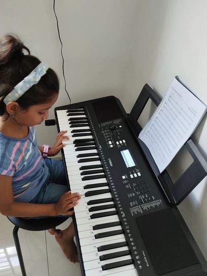 A young student practicing her scales on the keyboard.
