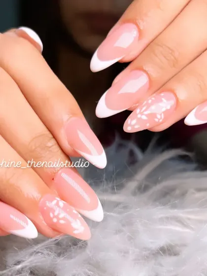 A closer look at the classic white French manicure with floral details.