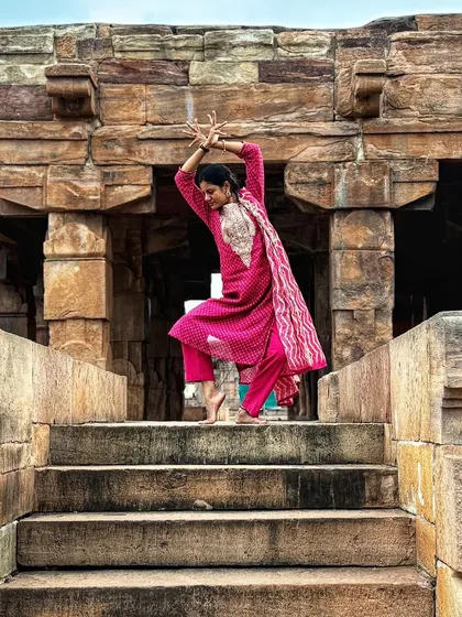 Striking a classical pose on the steps of a temple, connecting with the centuries of art and history carved into the stone.