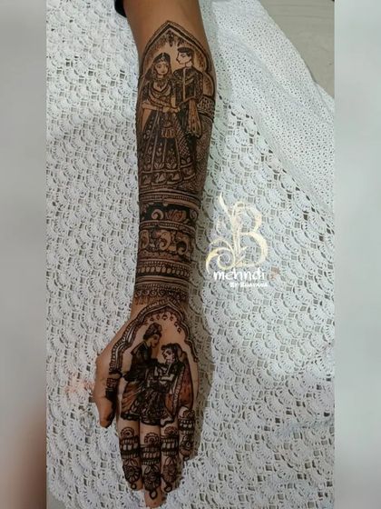 A full arm design featuring multiple stories. This custom bridal henna includes a realistic couple portrait on the upper arm and another scene on the palm.