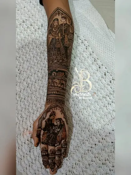 A full arm design telling a complete wedding story. It features a varmala ceremony portrait on the forearm and another couple portrait on the palm.