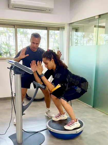 Namrata Purohit works on a BOSU ball while wearing the EMS suit, adding a significant balance and stability challenge. This combination of tools ensures a comprehensive, multi faceted workout.
