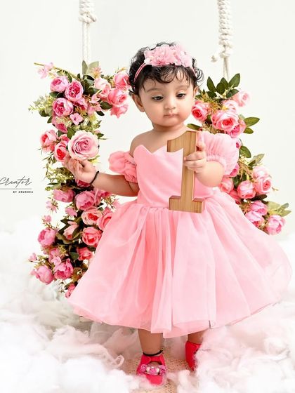 Standing tall and proud with her floral swing. Dressed in a beautiful pink gown, she holds a single rose, looking like a true fairytale princess.