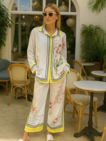 Step out in this stunning printed co-ord set, perfect for a brunch date or a summer evening. The design features a beautiful floral print on a white base, with bold yellow and black striped accents along the collar, placket, and hem. The relaxed fit of the shirt and wide-leg pants ensures you stay comfortable while looking fashionable.