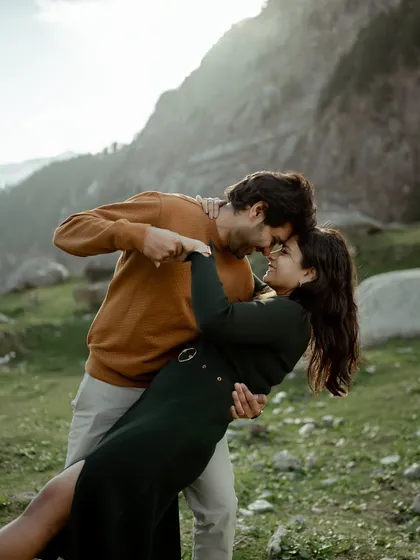 An intimate dance in the green meadows of the mountains. This close-up shot captures the couple lost in their own world, full of smiles and affection during their Manali pre-wedding shoot.