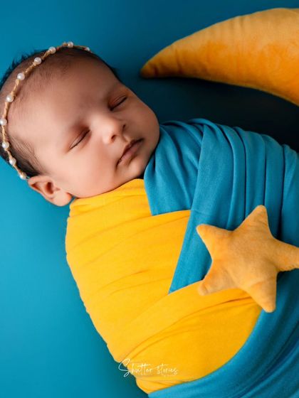 A full view of the blue and yellow moon and stars setup, creating a bright and cheerful newborn photo.