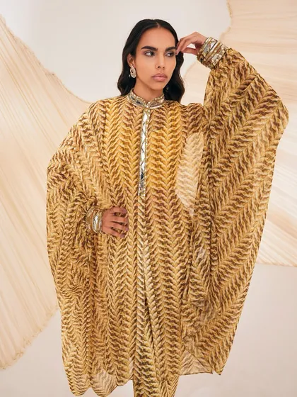 Our Riley Kaftan set in a yellow chevron print, infused with utter grace. The look features mirrorwork and a breezy silhouette.