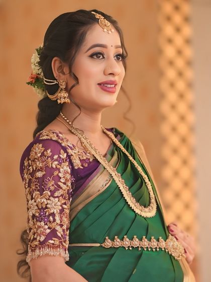 This purple net blouse was a joy to create for my dear client Sowmya's baby shower. The sheer sleeves are adorned with delicate, hand-embroidered floral vines in gold threadwork, creating a look of ethereal elegance for her special day.