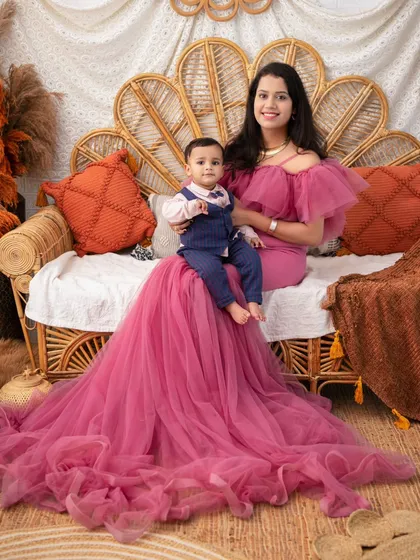 A mother and son portrait in our autumn-themed setup. The mother's dramatic pink gown provides a stunning contrast to the warm, earthy tones of the backdrop.