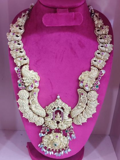 A traditional Lakshmi coin haram with a large temple-style pendant, available for rent.