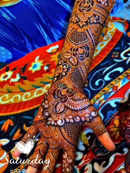 A close up shot showing the rich color and detail of a floral and paisley mehendi design.