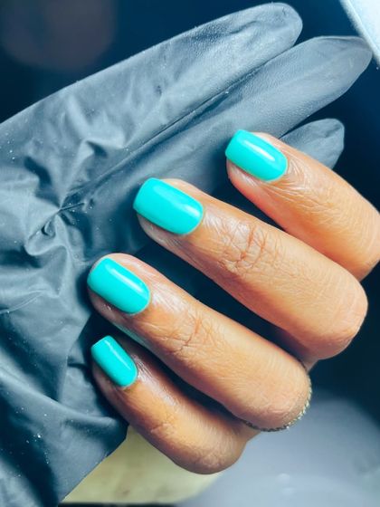 A bold and confident look with this vibrant turquoise gel polish on short, square nails.