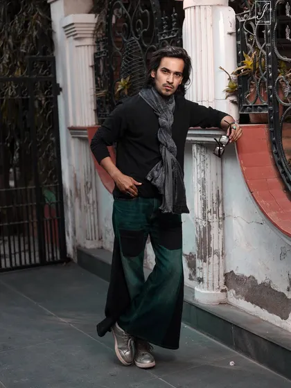 A full-body shot that shows how the wide-leg pants and scarf create a unique, fashion-forward silhouette.