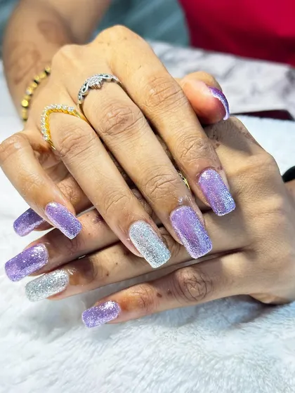 A beautiful combination of purple and silver glitter on long square nails.