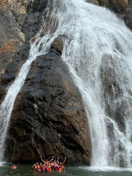 A small group dwarfed by the sheer size of Dudhsagar falls. This shot captures the immense scale and power of this natural wonder.