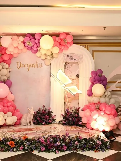 A whimsical butterfly garden theme, where shades of pink and purple create a magical atmosphere. This stage design features large, illuminated butterfly wings, a floral-print floor, and balloon clouds, making it feel like a fairy tale.