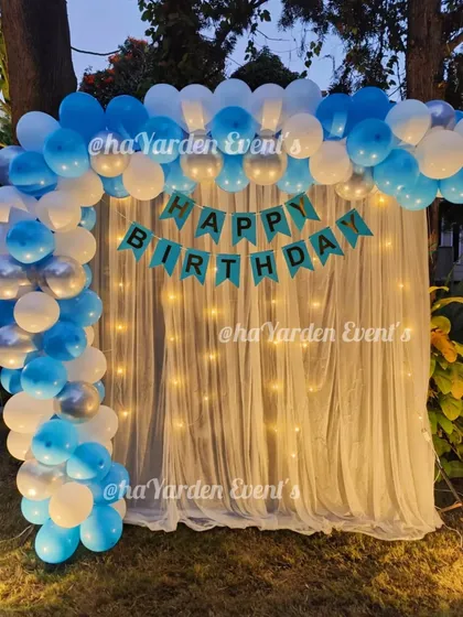 A closer view of the outdoor balloon and fairy light curtain setup, creating a magical ambiance as the sun sets.