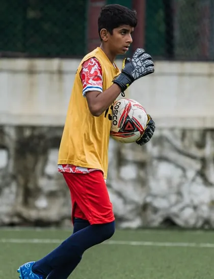 Our goalkeeper in action, securing the ball during a training match. We provide specialized goalkeeper training to develop this crucial position.