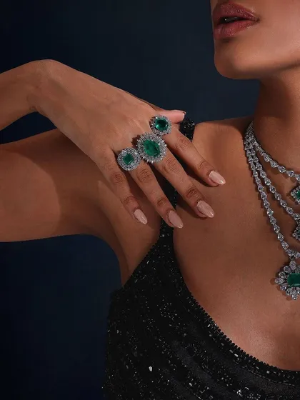 A detailed shot focusing on the emerald rings and layered necklace from Purab Paschim's "Luminance" collection.