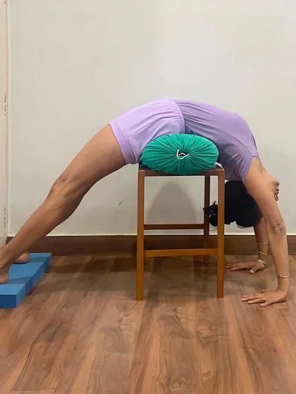 Here, I practice a supported Urdhva Dhanurasana on a stool with bolsters. The back of your body is unseen, like your nervous system. Backbends draw you from the externally oriented front brain into the deep recesses of the back brain and the intuitive mind.