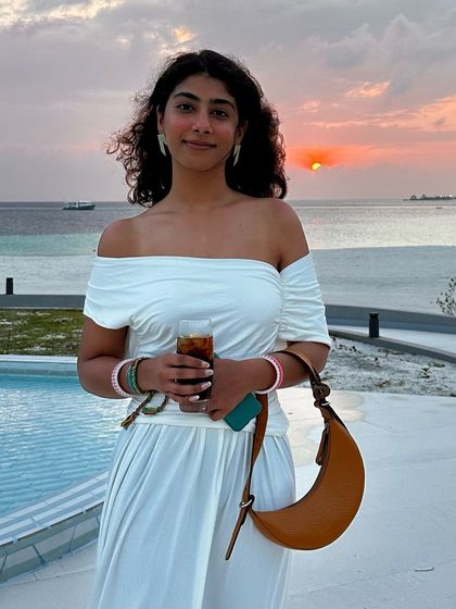 Taking my Selena Tan Croc on vacation. Its classic color and timeless design make it the perfect travel partner, seen here against a beautiful sunset.