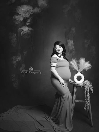 A beautiful black and white fine art portrait, capturing the mother-to-be in a moment of quiet grace and elegance.