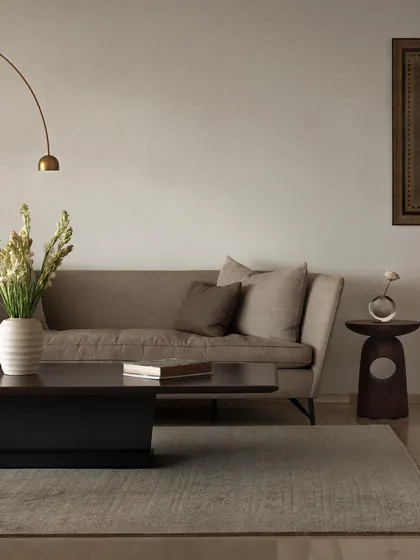 We designed the furniture in this living room to create a soft, elegant, and cohesive space. The low-profile coffee table, sculpted wooden side table, and arched floor lamp work together to establish a calm and inviting atmosphere.