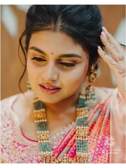 A close-up of the beautiful Varsha. This shot highlights the soft, blended eyeshadow and the messy, romantic updo we created for her, showing the importance of texture in a bridal look.