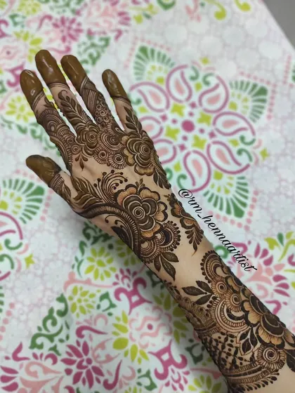 A full view of this floral and leafy back-hand design. The pattern extends from the wrist to the fingertips, creating a very elegant look.